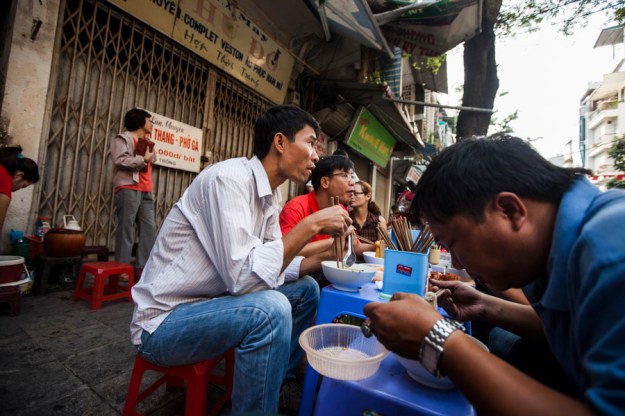 Eating pho on the street at 9 Hang Trong street in downtown Hanoi, Vietnam.